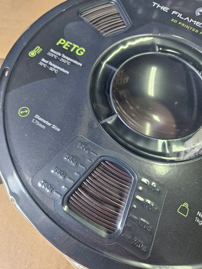 Close-up of a 3D printing filament spool with branding and specifications.