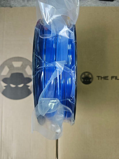 Spool of blue cable on a cardboard surface