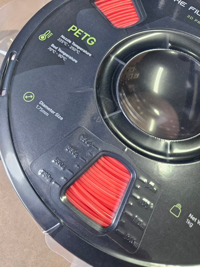 Close-up of a spool of PETG filament with red and black design elements.
