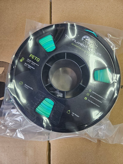 Spool of filament with branding on a cardboard background