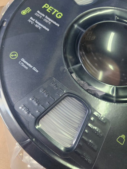 Close-up of a spool of PETG filament with specifications on a clear background