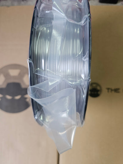 Clear plastic sheet with a circular object underneath on a beige background