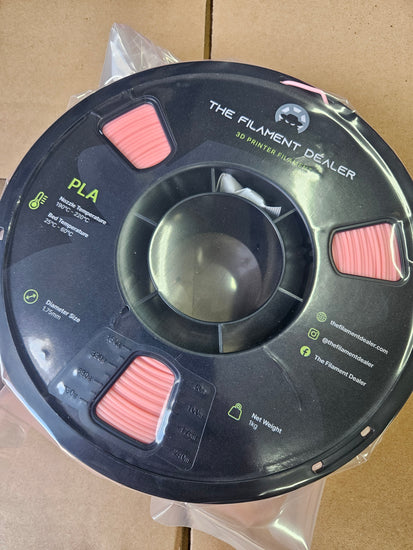 Spool of filament labeled 'The Filament Peeler' on a cardboard background