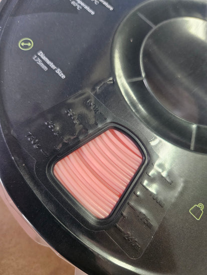 Close-up of a black electronic device with a pink component