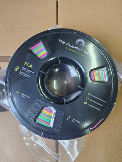 Spool of filament with colorful labels on a cardboard background