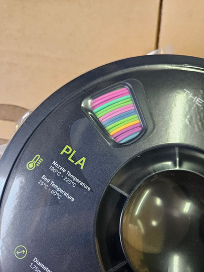 Spool of PLA filament with temperature information on a cardboard background
