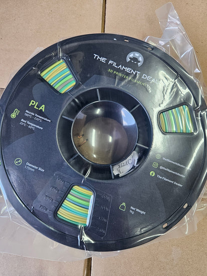 Spool of PLA filament with branding on a cardboard background